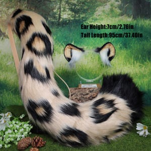 Puede incluir: Un conjunto de cola y orejas de piel sintética con estampado de manchas en crema, negro y marrón claro. La cola mide 95 cm de largo. Las orejas miden 7 cm de alto. Para cosplay o disfraces.