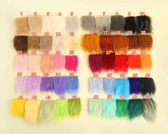 May include: A collection of 50 swatches of faux fur in various colors, arranged in rows. Colors range from light neutrals to vibrant hues, including shades of pink, blue, green, and orange. Each swatch is labeled with a number.