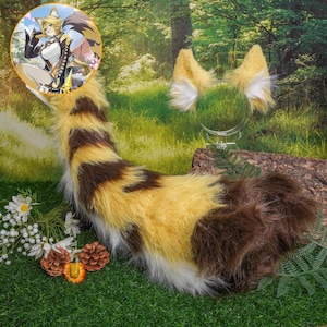 Può includere: Un costume da coda di gatto soffice marrone e giallo con un paio di orecchie di gatto abbinate. Le orecchie sono bianche con una punta gialla e hanno un motivo a strisce marroni e gialle.