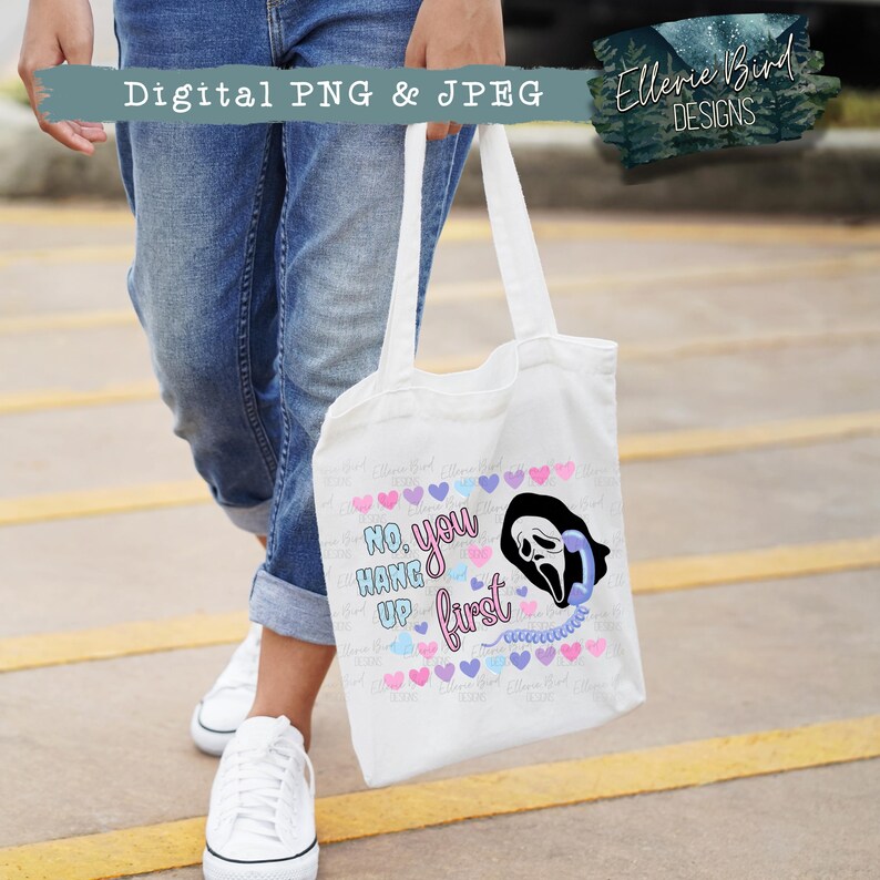 K&ouml;nnte beinhalten: Wei&szlig;e Tragetasche mit einem Grafik des Scream-Maske und einem Telefon, mit dem Text "NO, YOU HANG UP first" in Pink und Blau. Das Design ist von rosa, blauen und lila Herzen umgeben. Die Tasche wird von einer Person getragen, die blaue Jeans und wei&szlig;e Turnschuhe tr&auml;gt.