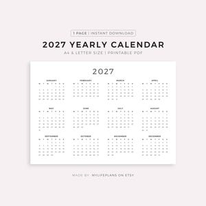 以下が含まれることがあります： ミニマリストデザインの白い2027年年間カレンダー。カレンダーは白い背景に印刷され、1年間の月がグリッド形式で配置されています。「2027 YEARLY CALENDAR」の文字が上部にあります。