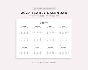 May include: A white 2027 yearly calendar with a minimalist design. The calendar is printed on a white background and features the months of the year arranged in a grid format. The text "2027 YEARLY CALENDAR" is at the top.