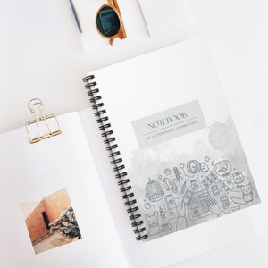 以下が含まれることがあります： 水彩画の背景と「Notebook of Veterinary Gibberish」というタイトルが書かれた灰色のスパイラルバインダーノート。表紙には、猫、犬、鳥、魚、医療用品など、獣医ケアに関連するさまざまなイラストが描かれています。