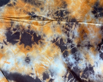 May include: A fabric with a tie-dye pattern in shades of brown, orange, and white.