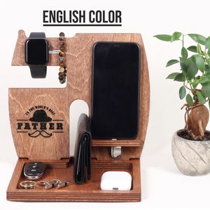K&ouml;nnte beinhalten: Holzorganizer mit F&auml;chern f&uuml;r ein Telefon, eine Uhr und Schl&uuml;ssel. Er hat eine braune Oberfl&auml;che und die Worte "To the world's best Father" sind auf der Vorderseite eingraviert.