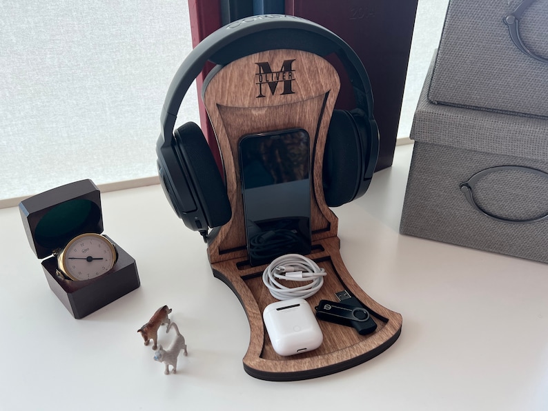 Pode incluir: Um suporte para fones de ouvido de madeira com um suporte para telefone, um pequeno compartimento de armazenamento e uma unidade USB. O suporte &eacute; personalizado com a letra "M" e o nome "Oliver".