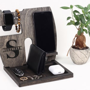 May include: A wooden organizer with a gray finish, featuring a phone stand, watch holder, wallet slot, and a tray for keys and other small items. The organizer is personalized with the name "JONATHAN" and a large "S".