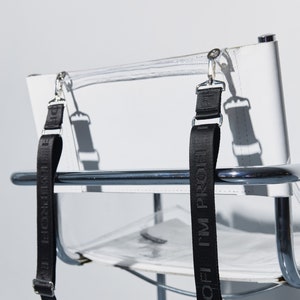 a clear chair with a black strap on it