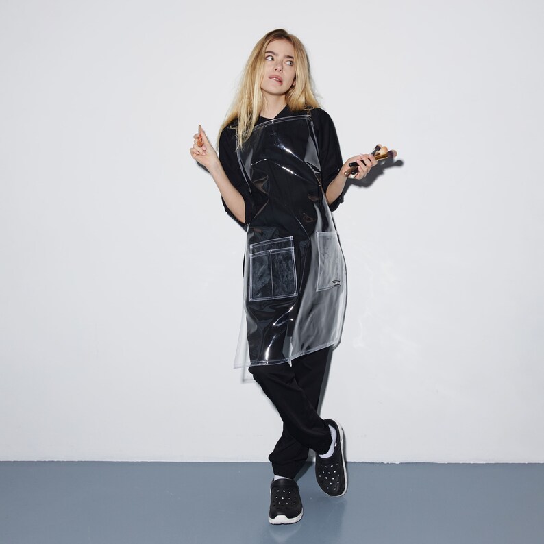 a woman in a black shirt and black pants holding a cigarette