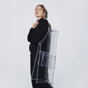 a woman in a black coat and a clear bag
