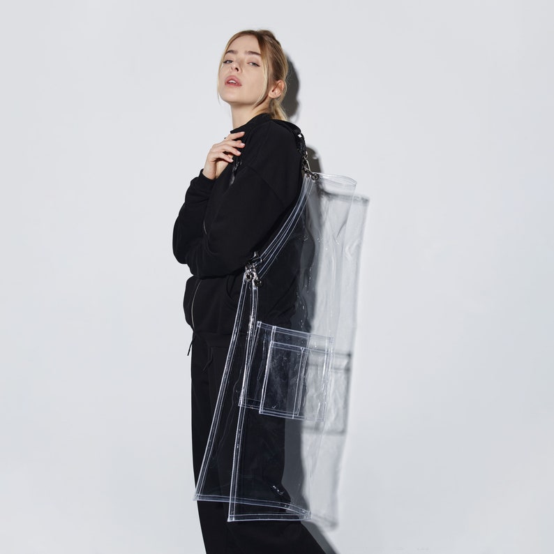 a woman in a black coat and a clear bag