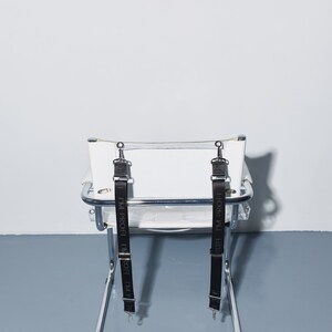 a white chair with two black straps on it