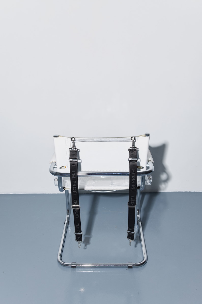 a white chair with two black straps on it