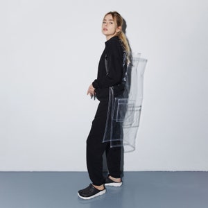 a woman standing in front of a white wall