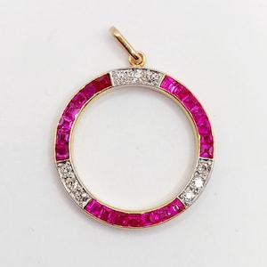 Puede incluir: Un colgante circular con una fianza dorada. El colgante presenta un anillo de rubíes cuadrados y una sección de pequeños diamantes. Los rubíes son de un rojo vibrante y los diamantes brillan sobre el oro. Una pieza de joyería clásica.