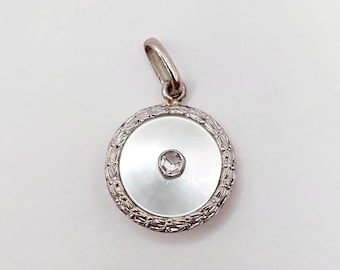 Art Deco-hanger in de vorm van een schietschijf, vervaardigd uit 18-karaats goud, platina, een roosgeslepen diamant en parelmoer (circa 1920).