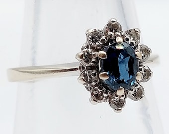 Anello a margherita in oro bianco 18 carati ornato da uno zaffiro da 0,45 carati e 10 diamanti a taglio brillante (circa 1960) art deco