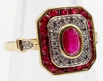 French art deco ring 18k gold set with an oval ruby surrounded by diamonds and round rubies in an octagonal setting (circa 1960)