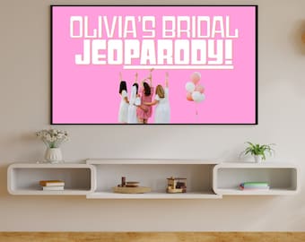 Op de afbeelding: Een roze achtergrond met de tekst "Olivia's Bridal Jeopardy!" in wit. Vier vrouwen staan in een rij, met hun rug naar de camera, met hun armen in de lucht. Er zijn roze en witte ballonnen die in de lucht zweven.
