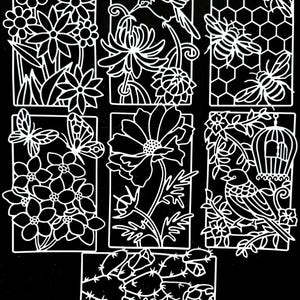 May include: A set of eight white die-cut paper designs featuring floral, bird, and bee motifs. The designs are intricate and detailed, with delicate lines and curves. The designs are perfect for scrapbooking, card making, and other paper crafts.