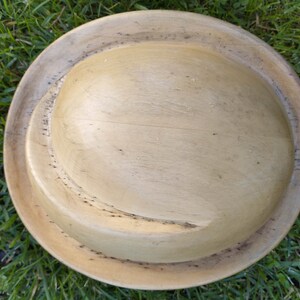 May include: A wooden bowl with a natural finish. The bowl has a deep, rounded shape and a smooth, polished surface.