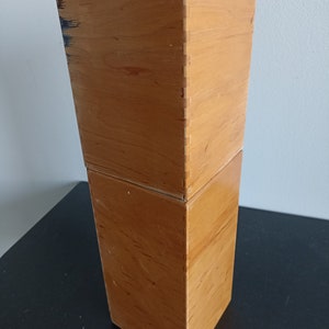 Op de afbeelding: Twee houten dozen op elkaar gestapeld. De dozen zijn gemaakt van lichtbruin hout en hebben een gladde afwerking.