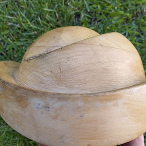 May include: A wooden hat block for millinery, with a light brown color and a smooth, slightly textured surface.