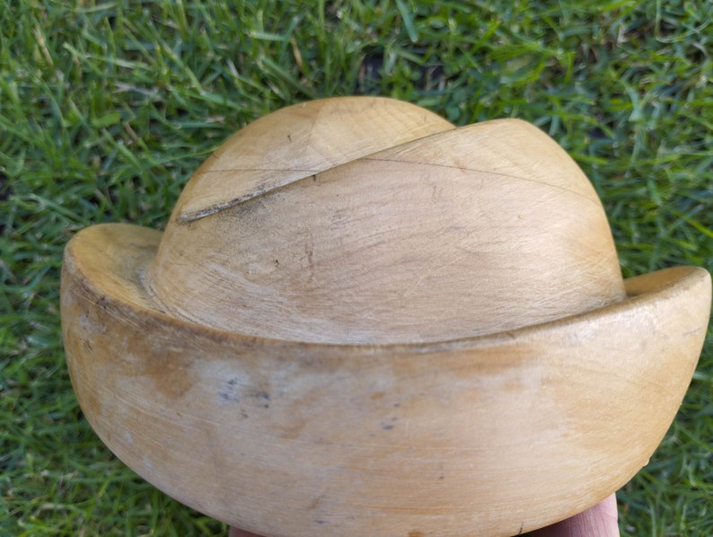 May include: A wooden hat block for millinery, with a light brown color and a smooth, slightly textured surface.