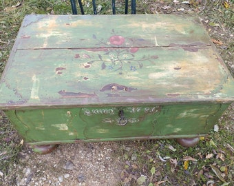 May include: Antique green wooden chest with a floral design painted on the top. The chest has a metal handle and the date "1796" is painted on the front.