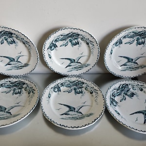 Puede incluir: Seis platos ovalados blancos con un diseño floral azul y blanco y un pájaro azul en vuelo. Los platos tienen un borde festoneado.
