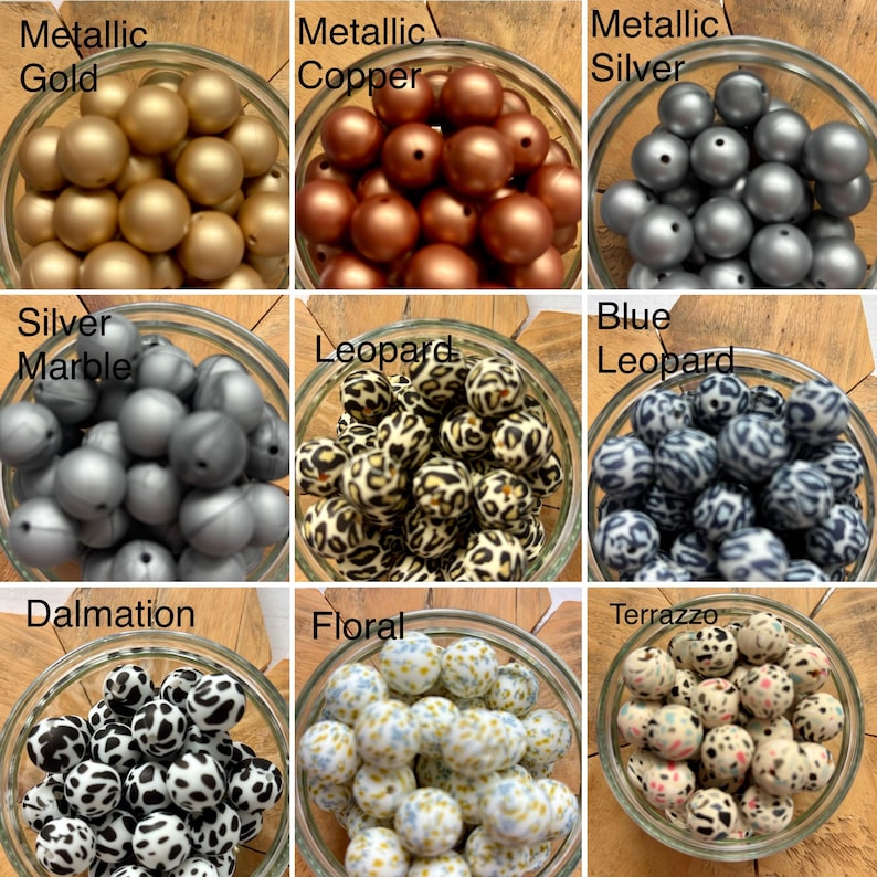 May include: A collection of nine glass bowls filled with round beads in various finishes and patterns, including metallic gold, copper, silver, silver marble, leopard print, blue leopard, dalmatian, floral, and terrazzo designs.