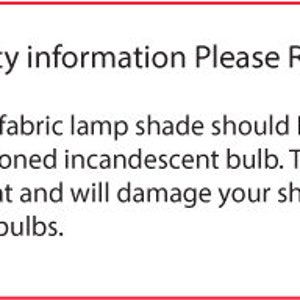 May include: A white rectangular sign with a red border. The text reads "Safety information Please Read." The sign warns against using incandescent bulbs with handmade fabric lamp shades, recommending LED or CFL bulbs instead.