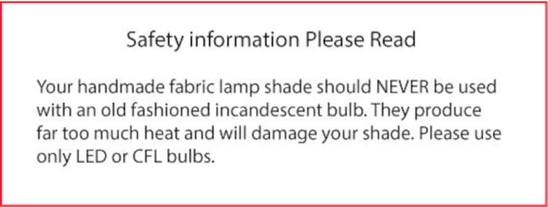 May include: A white rectangular sign with a red border. The text reads "Safety information Please Read." The sign warns against using incandescent bulbs with handmade fabric lamp shades, recommending LED or CFL bulbs instead.
