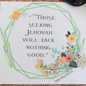 May include: White fabric with the text "THOSE SEEKING JEHOVAH WILL LACK NOTHING GOOD." surrounded by a green geometric design and floral accents in orange, pink, and blue. Psalm Thirty-Four Ten is written at the bottom.