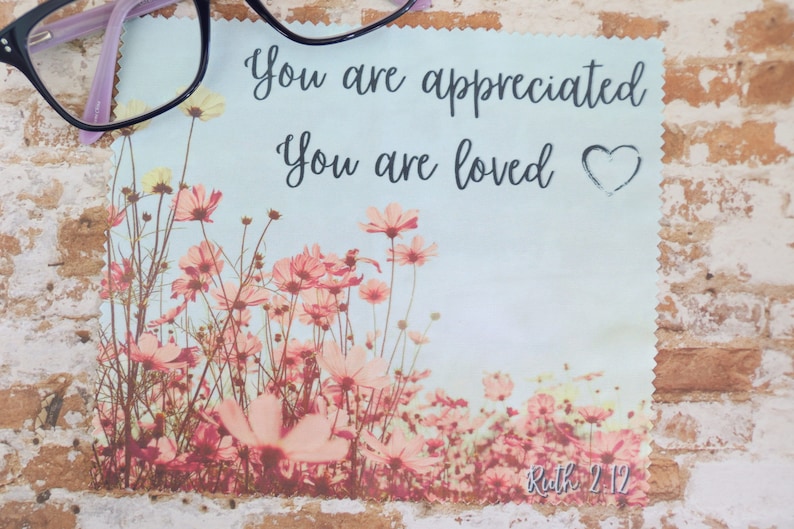 May include: A light blue microfiber cleaning cloth with a floral design and the text "You are appreciated. You are loved." with a heart symbol. The bottom of the cloth has the text "Ruth 2:12".