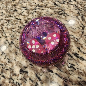 May include: A pink glitter sphere paperweight with two white dice inside.