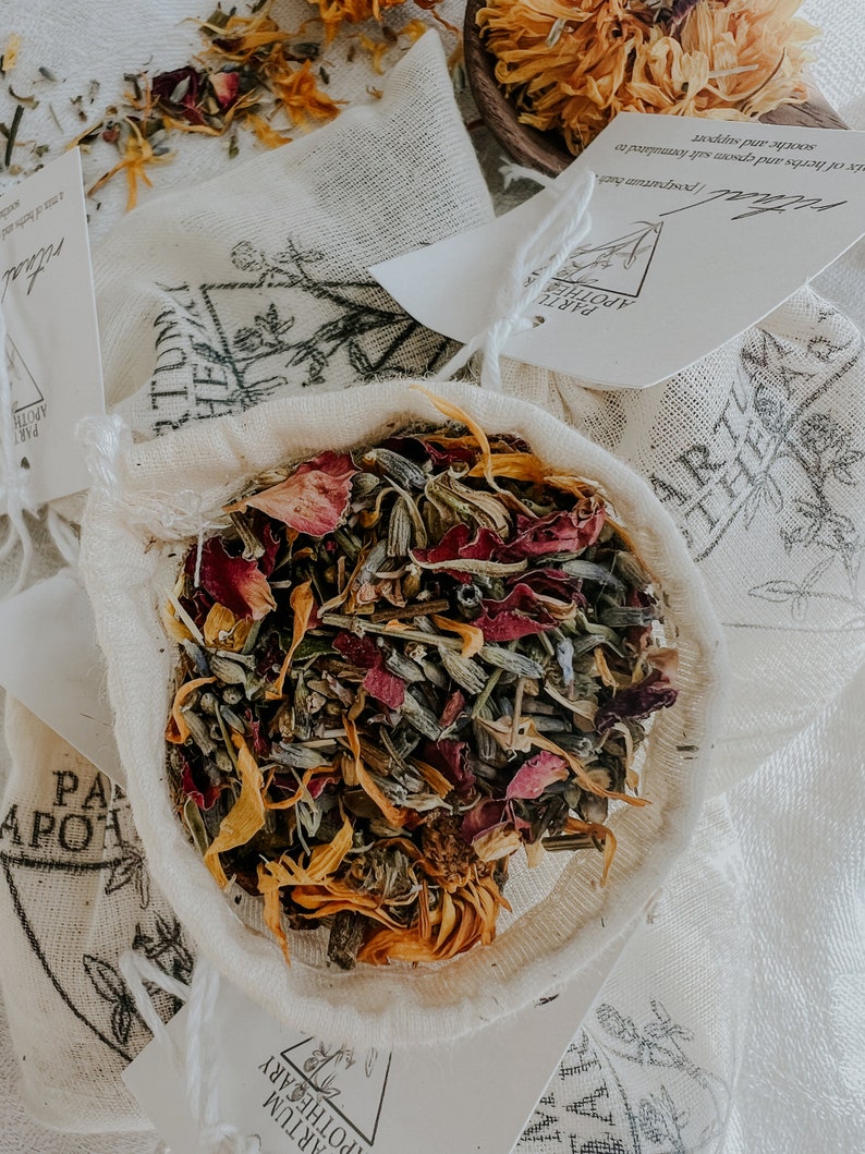 Close up of botanical ingredients in a sachet for baths with calendula, lavender, rose, and yarrow. This blend is used to heal the new mom postpartum from childbirth. This herb and salt blend relaxes muscles and can help reduce swelling and pain.