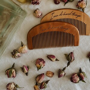 Two small brown hand held wooden comb for natural childbirth and natural pain relief.Dried rose buds scattered on birth alter on a white cloth