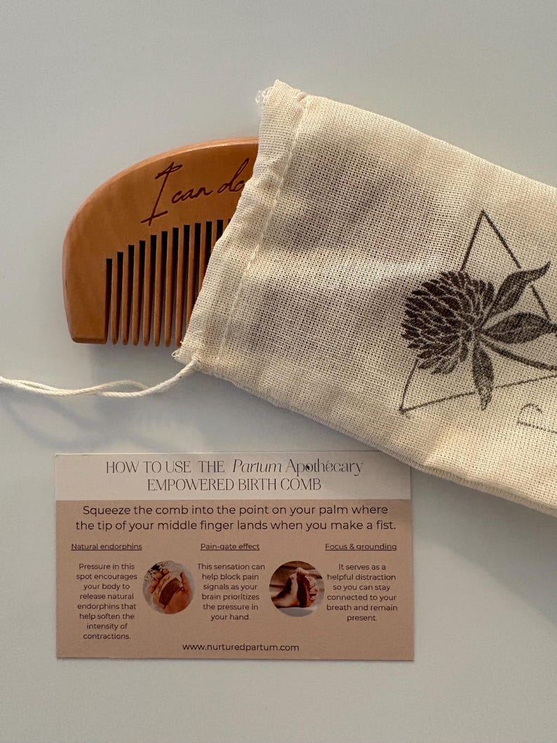 A birth comb is halfway out of it's carrying bag. The bag is engraved with a clover logo. Under the comb is a how-to card for using the comb.