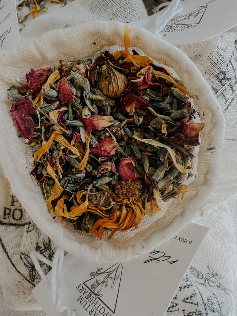 close up of botanical ingredients including uva ursi, calendula, lavender, rose, and yarrow, this herbal bath tea blend smells amazing and is designed to soothe. This herb and salt blend relaxes muscles and can help reduce swelling and pain.