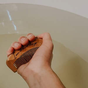 Mother holding wooden birth comb in a tub, gripping for natural pain relief with the affirmation I can do hard things.