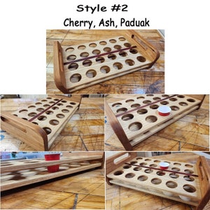 May include: A wooden shot glass holder with two tiers and a red stripe across the middle. The holder is made of cherry, ash, and paduak wood. The holder is shown with shot glasses in some of the slots.