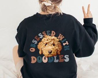 May include: Black sweatshirt featuring a brown doodle dog graphic and the text "Obsessed with Doodles" in a rainbow arc.