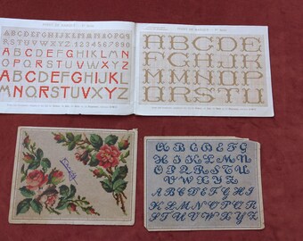 Peut inclure: Un ensemble de quatre feuilles de modèles de point de croix. Un grand livret ouvert affiche des grilles d'alphabets en rouge et beige. Une carte rectangulaire présente un motif de roses, et une autre montre une grille d'alphabet cursif bleu.