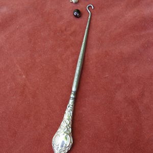 Edvardiansk silverknappkrok med handtag. Antik verktyg för att knäppa stövlar och skor, handskar