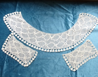 May include: A set of three white crocheted lace collars. The largest collar is a wide, curved shape, while the two smaller collars are square. All three collars feature a delicate floral pattern and a scalloped edge.