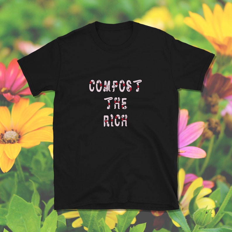 Op de afbeelding: Zwart T-shirt met de tekst "COMPOST THE RICH" in witte letters met rode accenten.