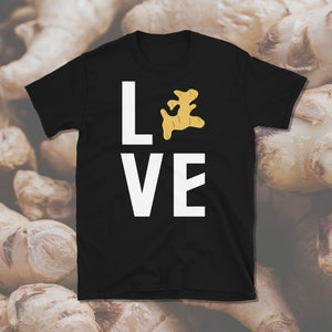 Op de afbeelding: Zwart T-shirt met witte tekst "LOVE" met een gemberwortel afbeelding die de "O" vervangt.