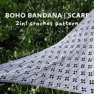 Könnte beinhalten: Ein hellgraues, gehäkeltes Bandana oder ein Schal mit floralem Muster wird vor dem Hintergrund von grünem Gras und weißen Blumen gezeigt. Der Text "BOHO BANDANA | SCARF 2in1 crochet pattern" ist sichtbar.