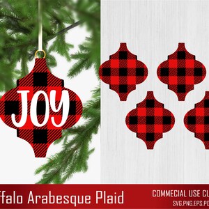 May include: Red and black buffalo plaid Christmas ornament with the word "JOY" in white. The ornament is shaped like a traditional arabesque design.